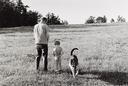Untitled  [Man And Boy Urinating In Field With Dog]